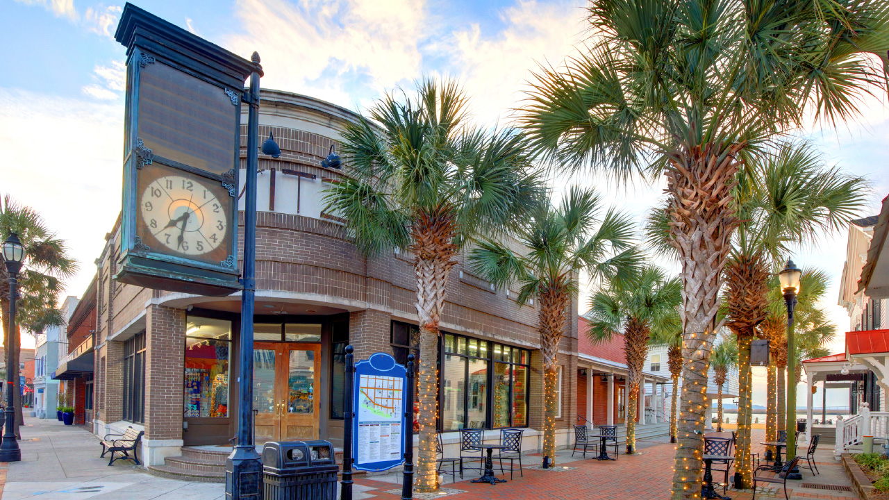  Downtown street with palm trees and clock tower, suggesting urban property and historical asset management
