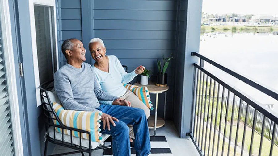  Senior couple enjoying a balcony view at a facility managed by asset management software for real-time monitoring
