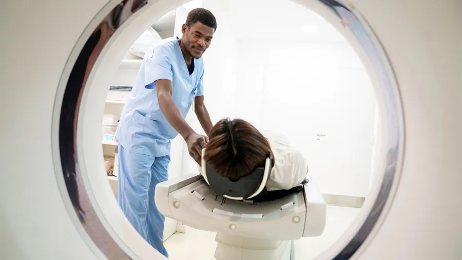  Medical professional assisting with a CT scanner, demonstrating healthcare equipment management in action.