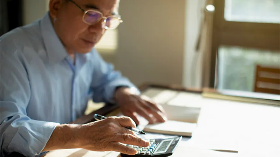 Man at a desk with a calculator.