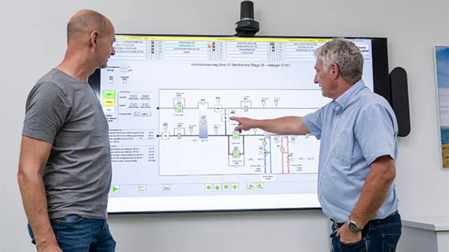 Two people pointing at a board discussing the data