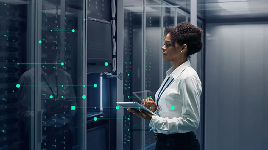 A person using tablet in data center, optimizing operations with advanced asset management software to boost efficiency.
